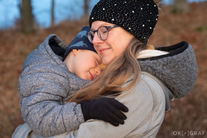 Rodinné focení v podzimním světle - chlapec v náručí matky. Okograf. Pavla Bernardová.