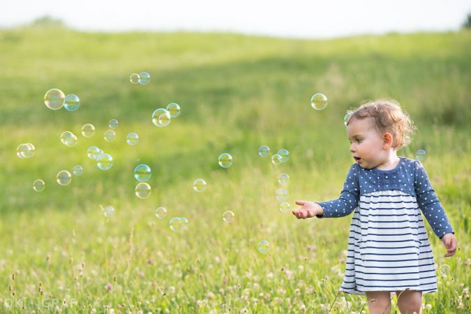 Dítě s bublinami na louce. OKograf. Pavla Bernardová.